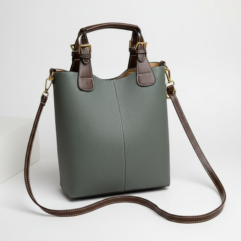 Gray handbag with brown handle and strap on a beige background