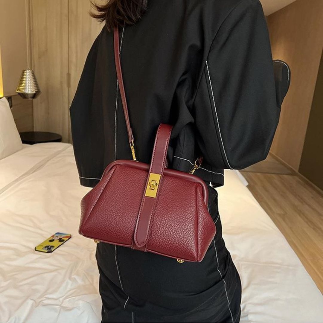 Person holding a red handbag in a bedroom setting