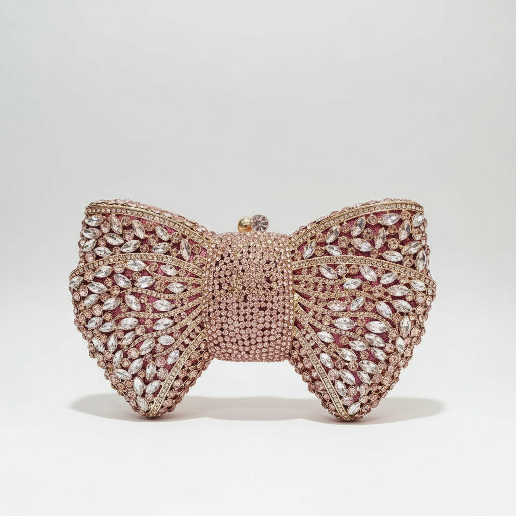 Rose gold butterfly-shaped clutch with crystal embellishments held by a hand, inset showing close-up of crystal details.