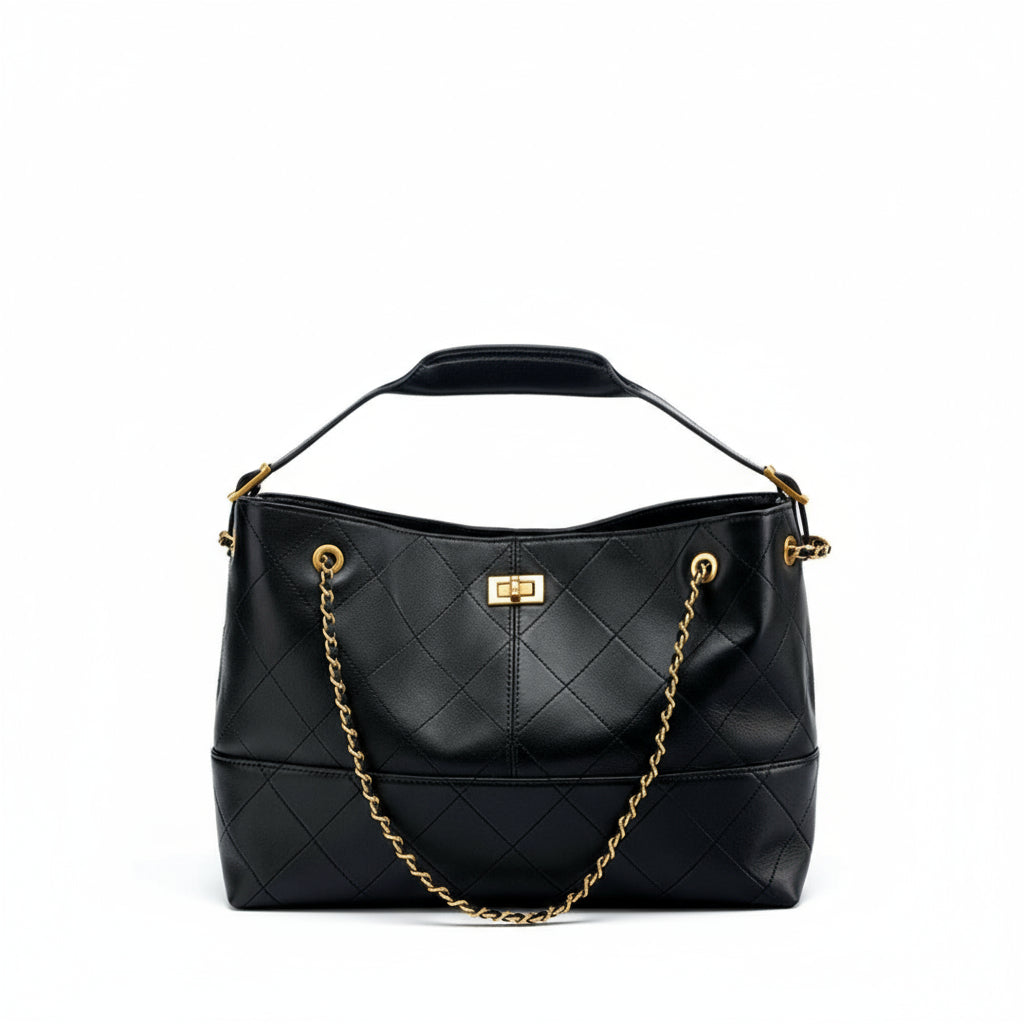 Black quilted handbag with gold chain and hardware on a white background
