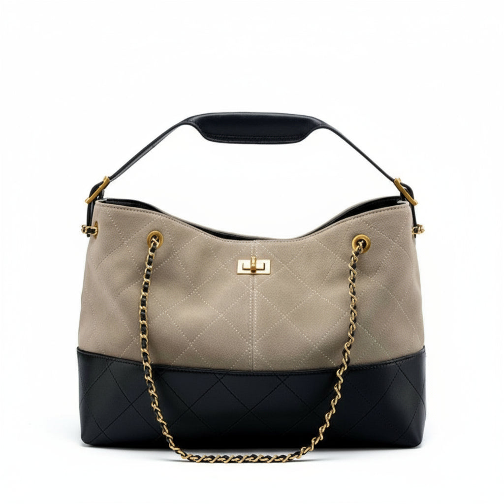 Quilted handbag with beige top half and black bottom half on a white background