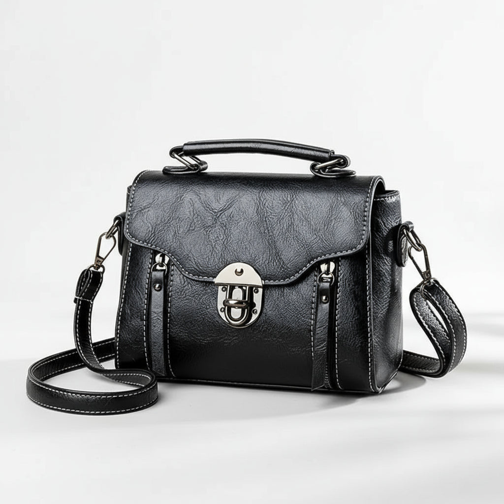 Black leather handbag with a silver lock on a brown background