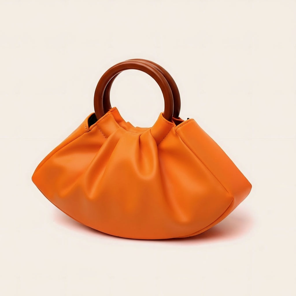 Orange handbag with wooden handle on a light beige background