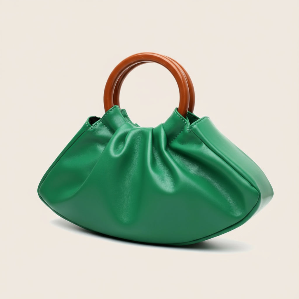 Green handbag with wooden handle on a beige background