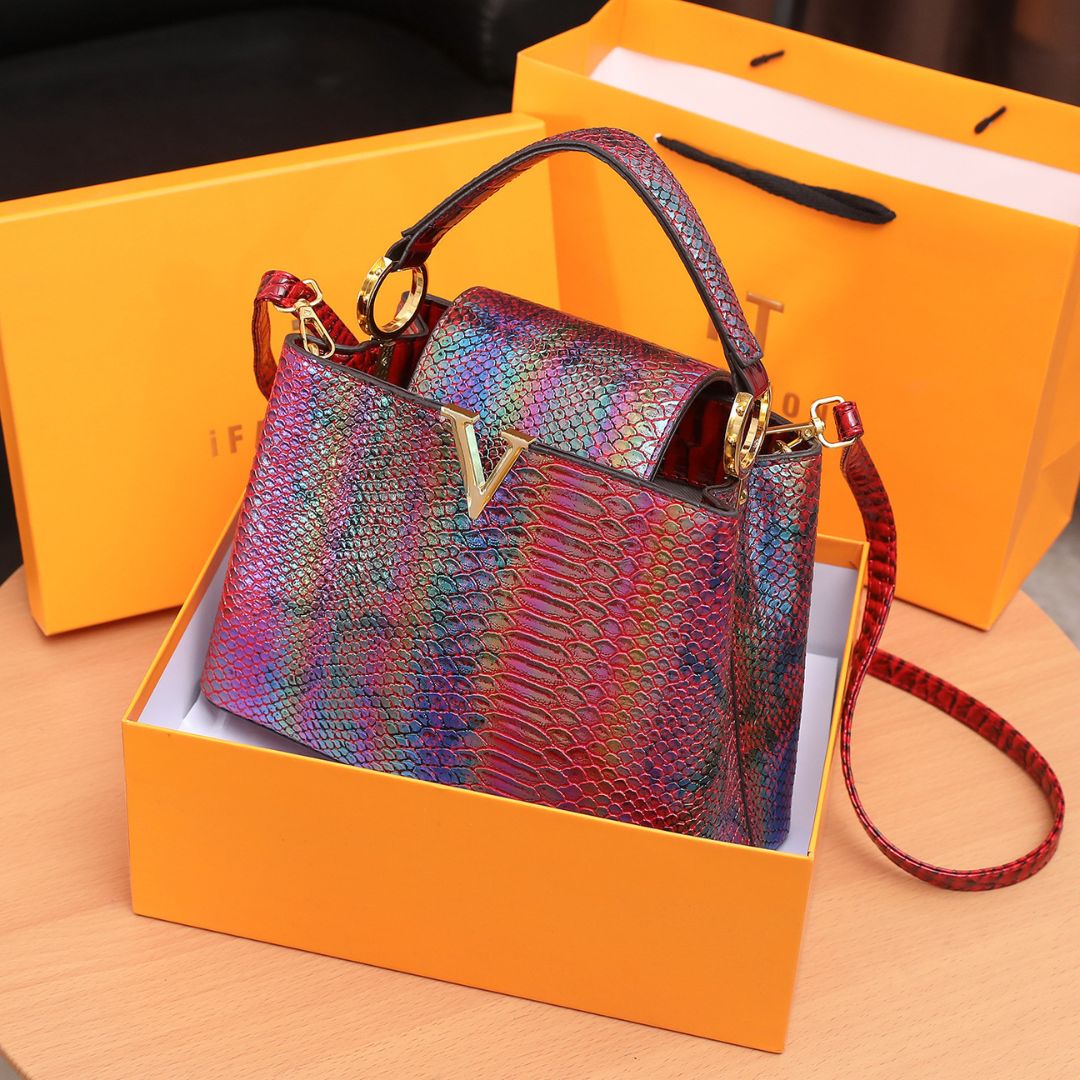 Multicolored handbag with red strap in an orange box