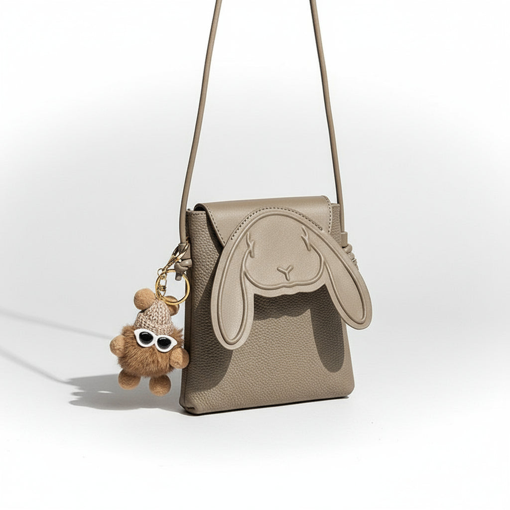 Beige handbag with bunny design and matching keychain on a light surface