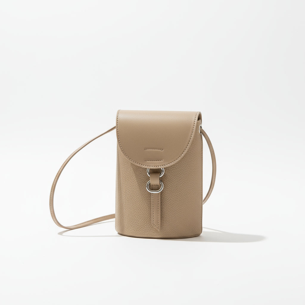 Beige leather handbag with a strap on a neutral background