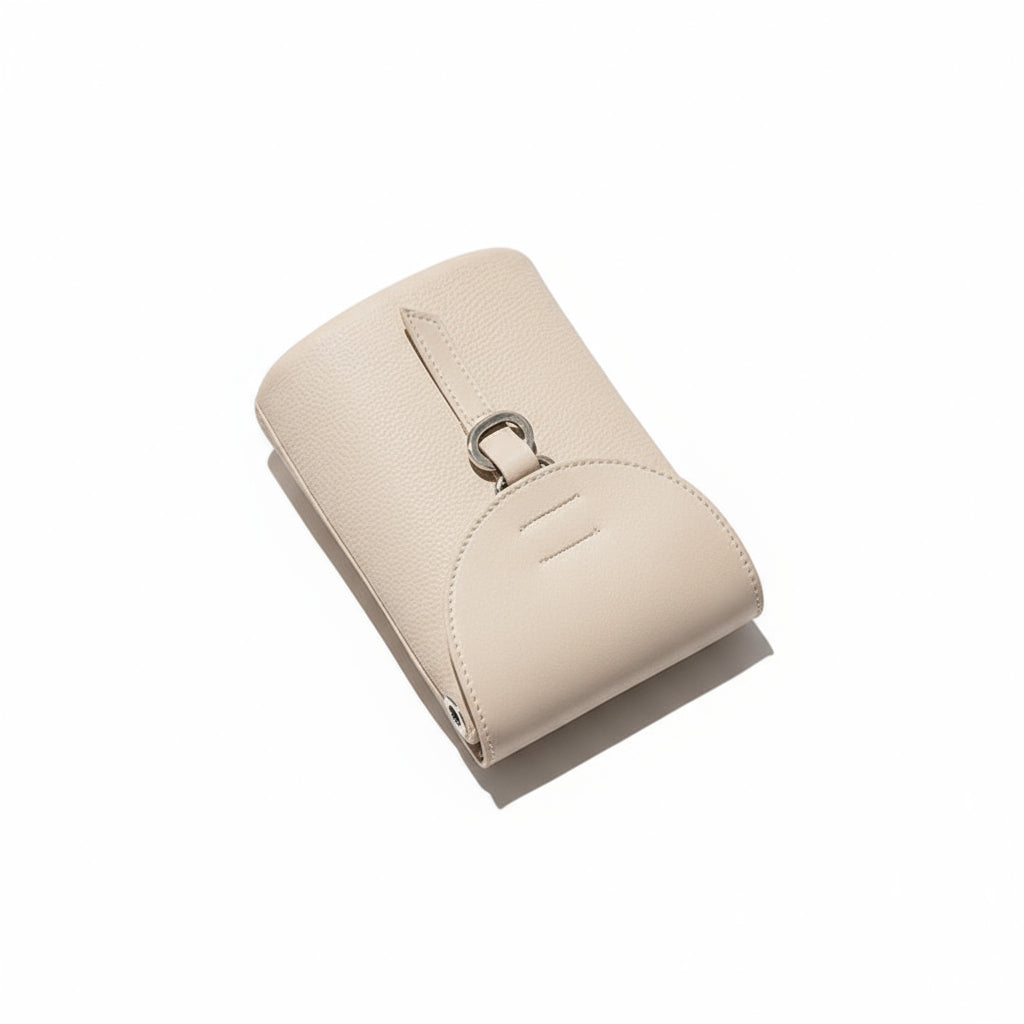 Beige handbag with a strap on a textured surface