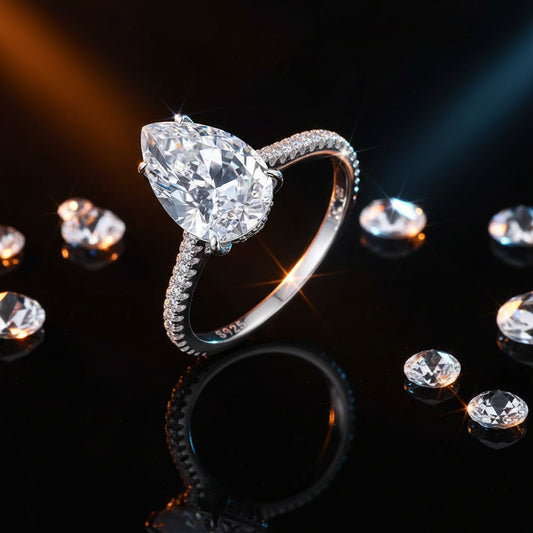 Diamond ring with a pear-shaped center stone on a black background