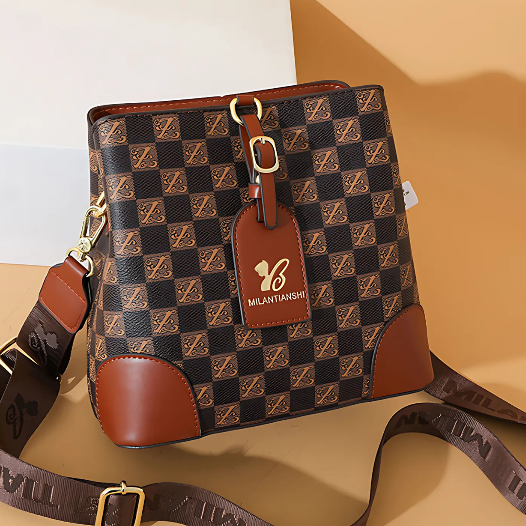 Brown and black checkered handbag with a visible brand tag on a beige background