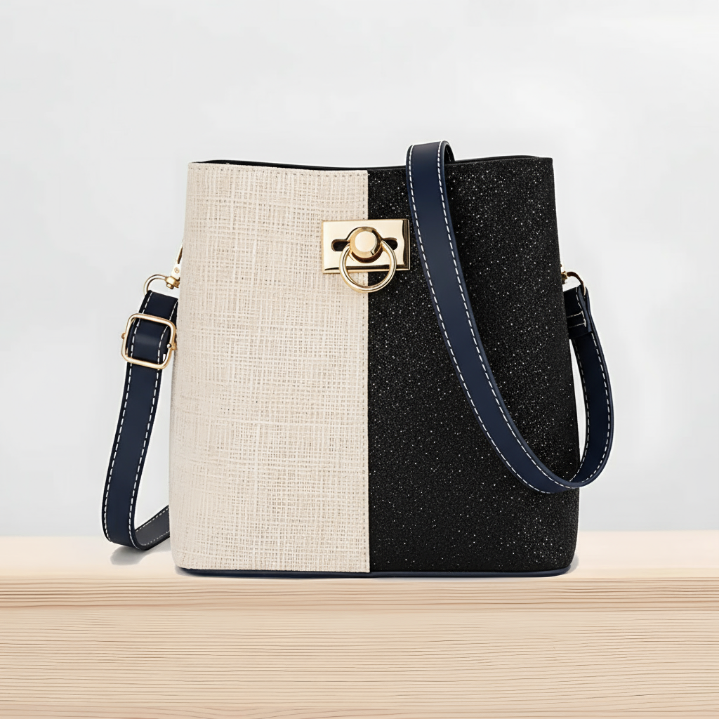Two-tone handbag with beige and black pattern on a light gray background
