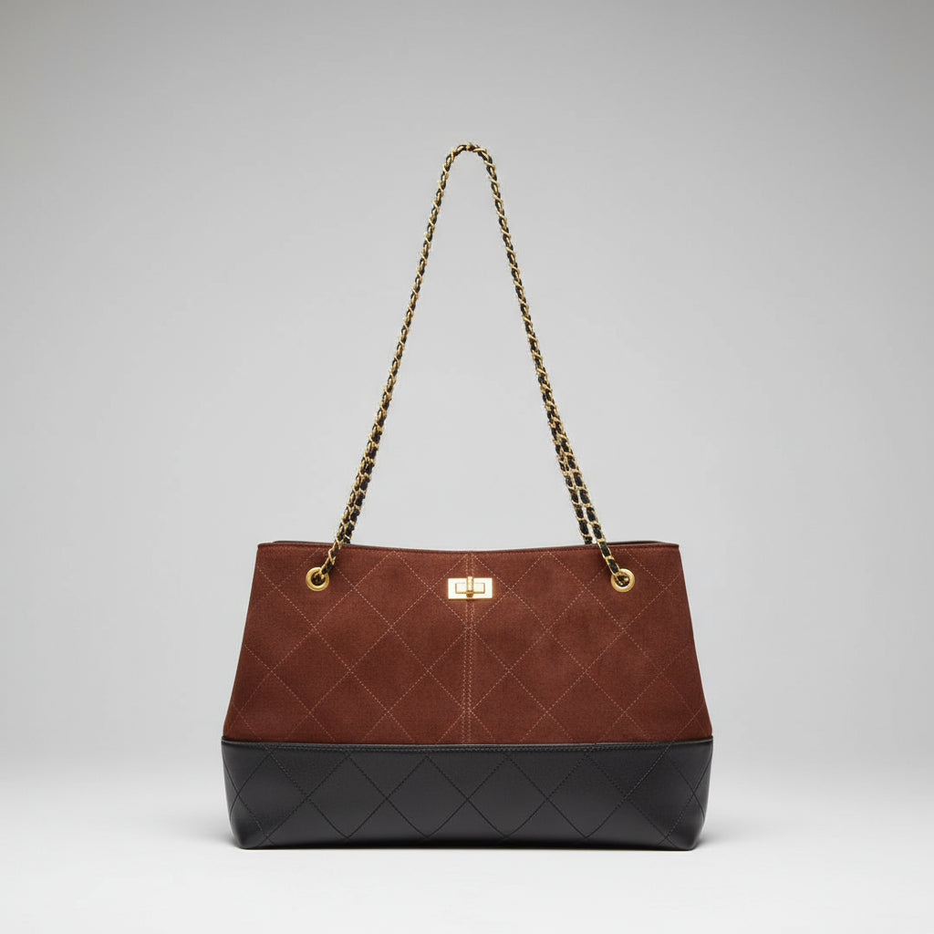 Brown quilted handbag with gold chain strap on a pink background