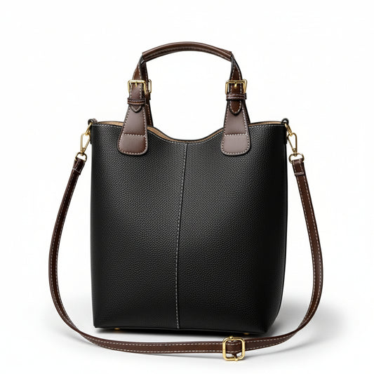 Black handbag with brown accents on a beige background