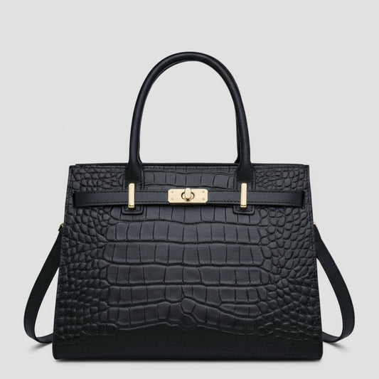 Black crocodile-patterned handbag with gold hardware on a white background