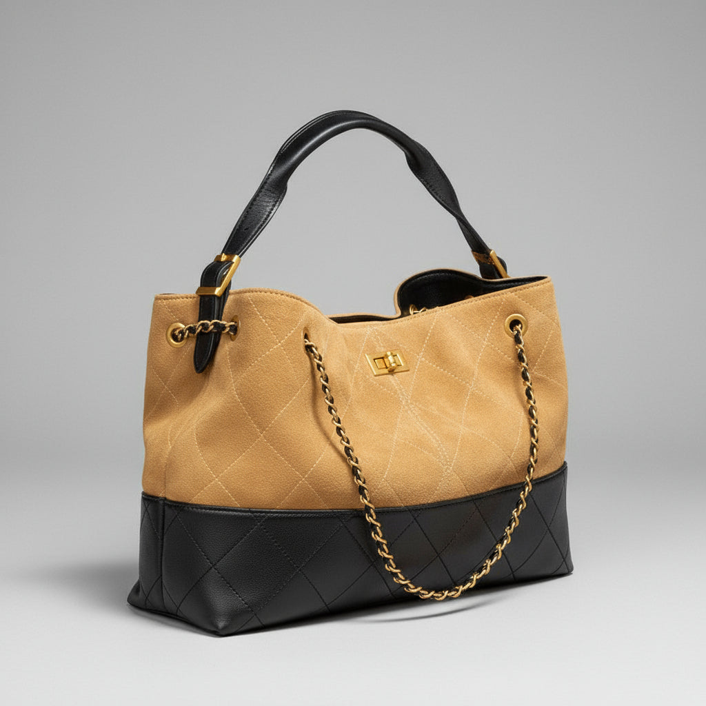 Quilted handbag with gold chain detail on a brown surface with a pink background