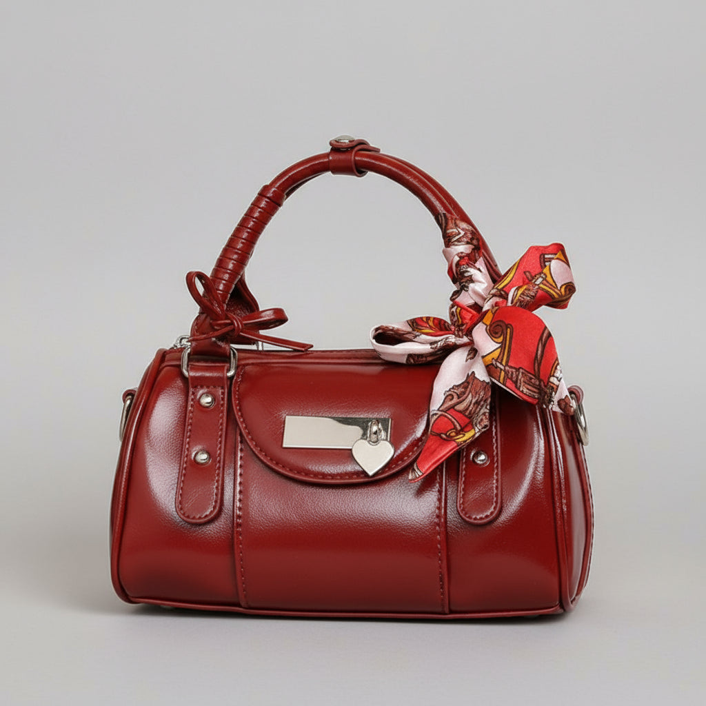 Red handbag with a decorative ribbon on a beige background