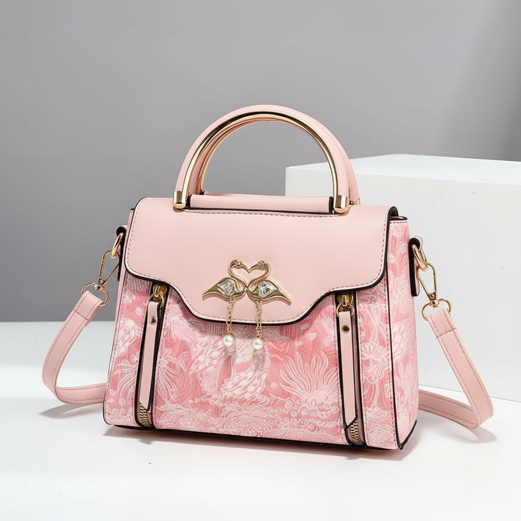 Pink handbag with floral design and decorative elements on a gray background