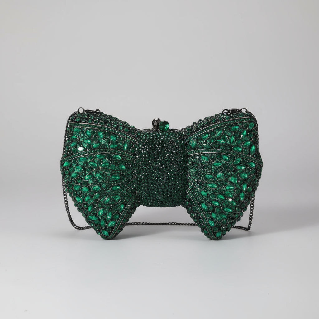 Green beaded bow clutch bag on a white surface with a neutral background