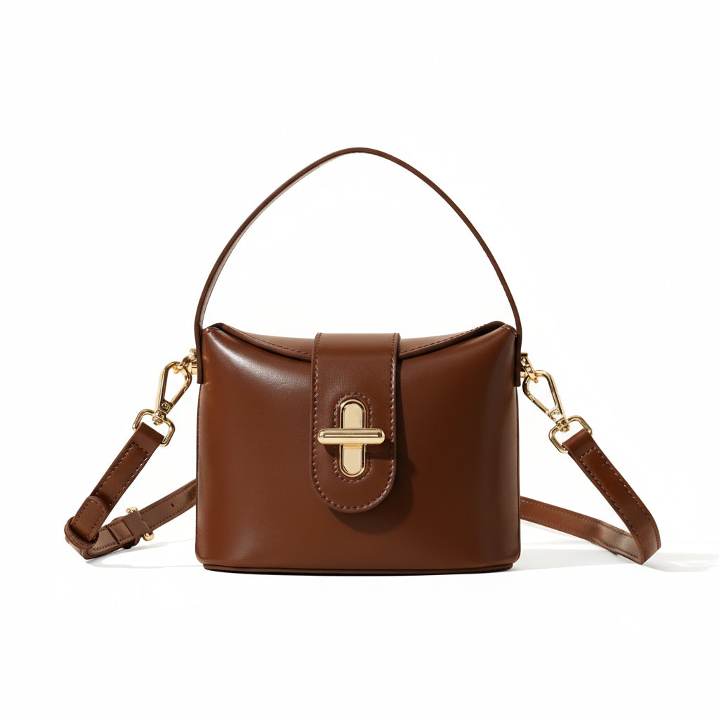 Brown handbag with gold accents on a beige background