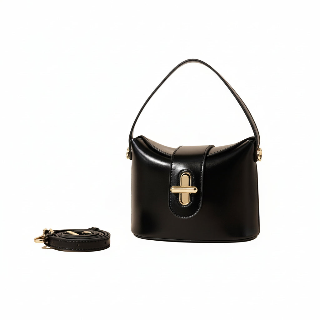 Black handbag with a gold clasp on a beige background