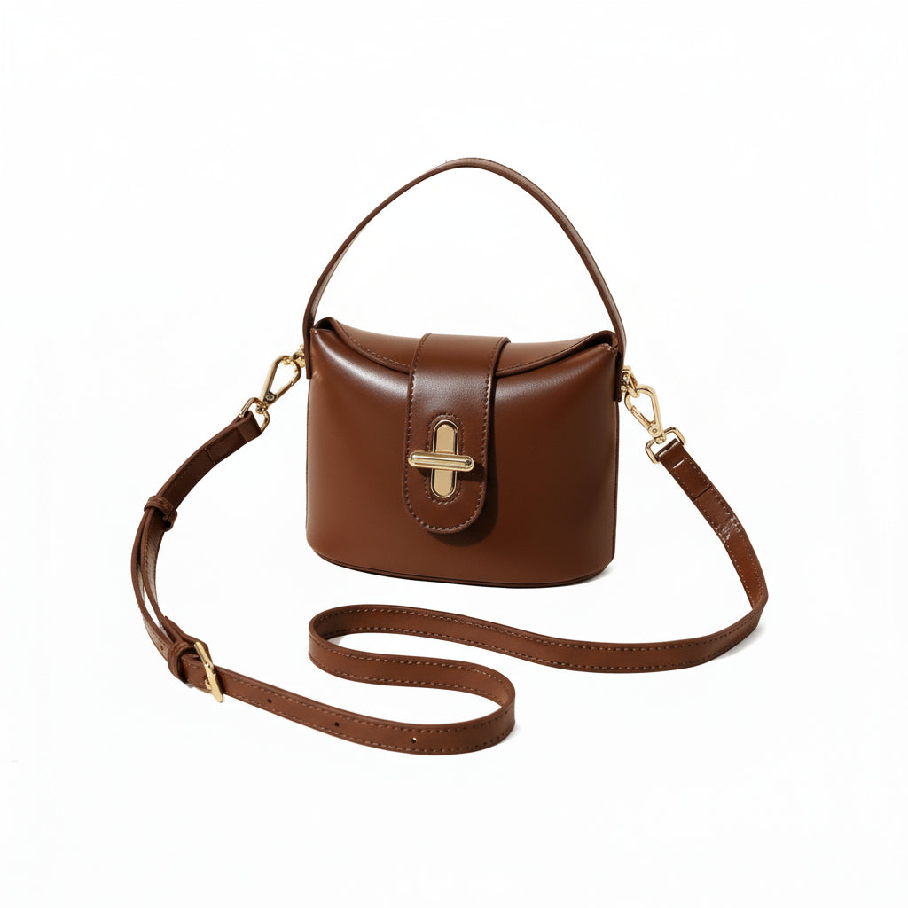 Brown leather handbag with a strap on a beige background