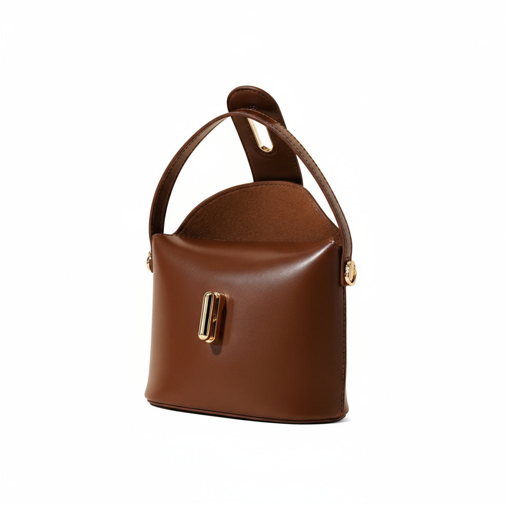 Brown leather handbag with a gold clasp on a beige background
