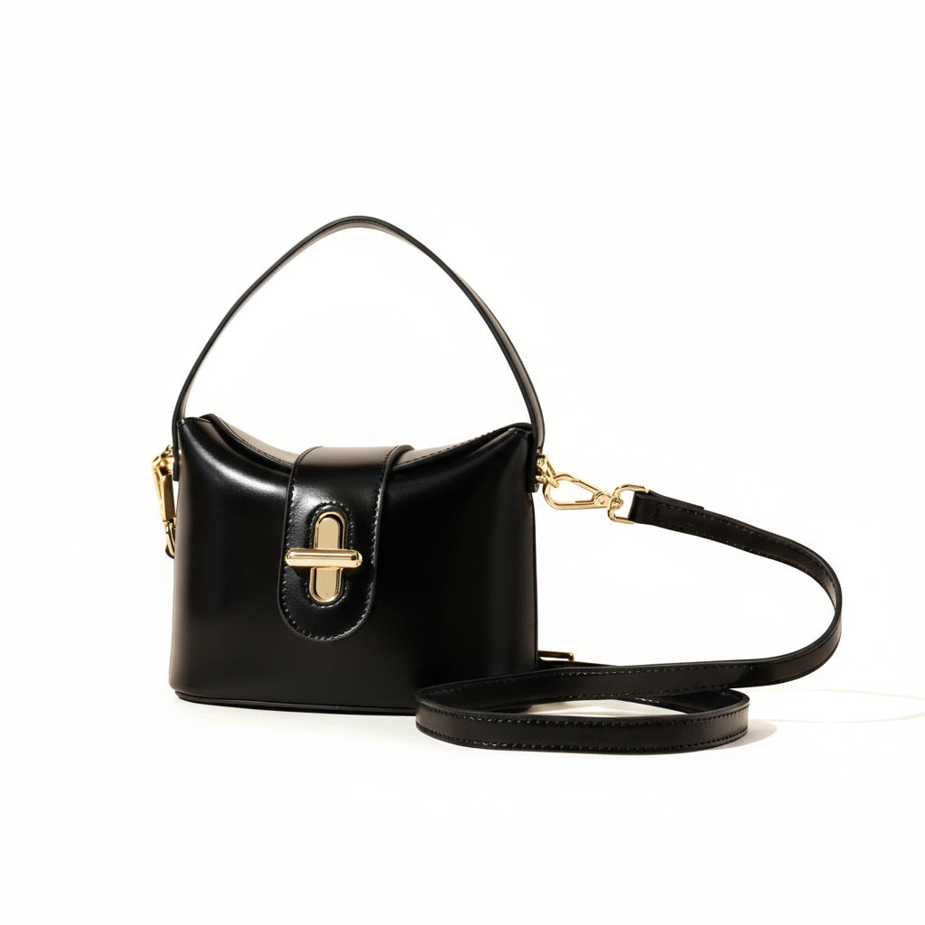 Black handbag with gold accents on a beige background
