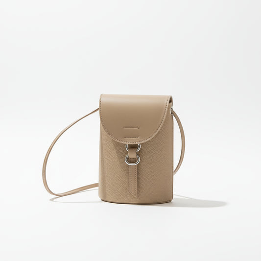 Beige leather handbag with a strap on a neutral background