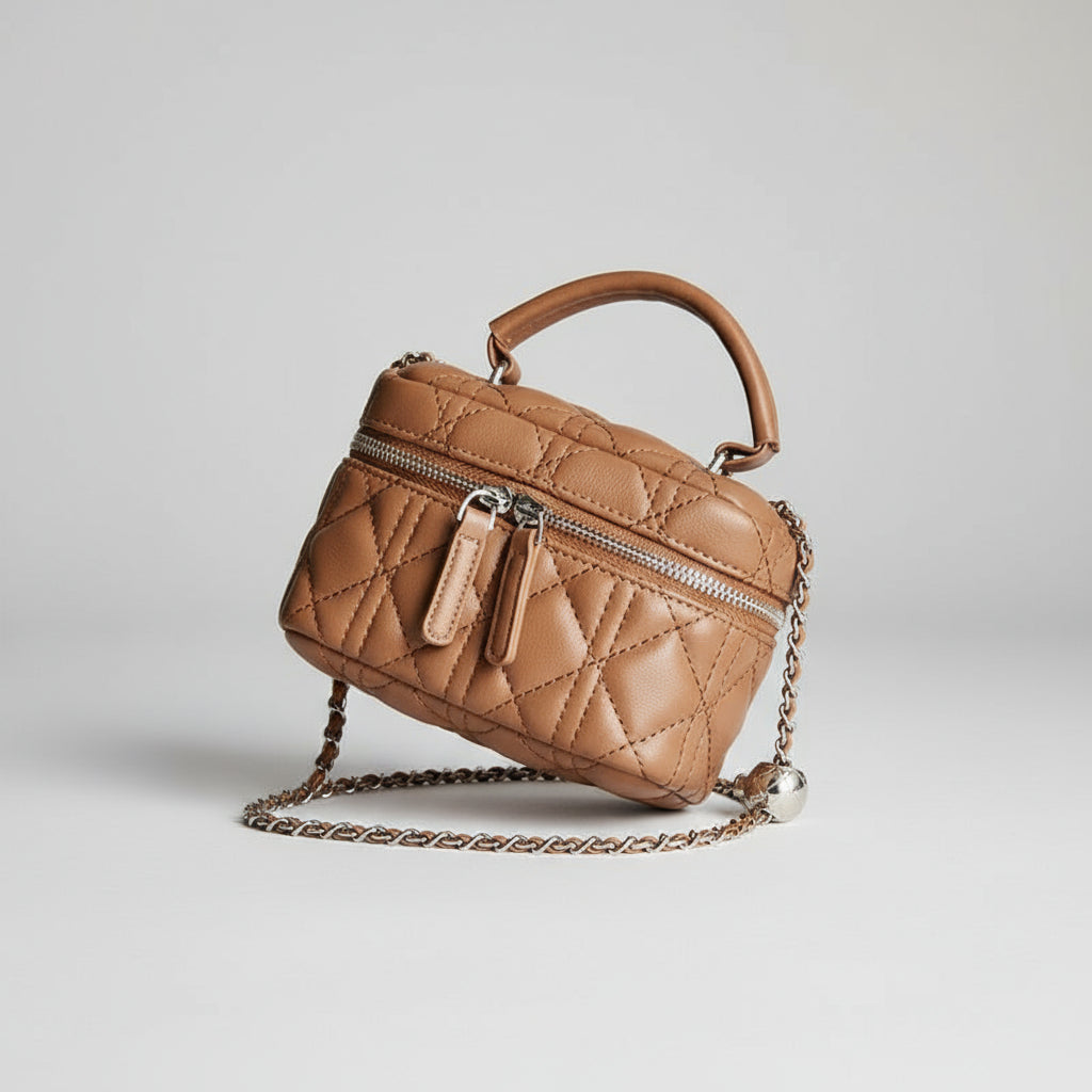 Quilted brown handbag with chain strap on a wooden surface