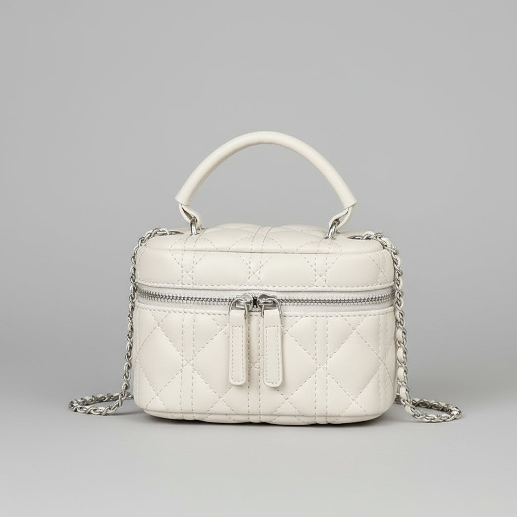 White quilted handbag with a chain detail on a wooden surface