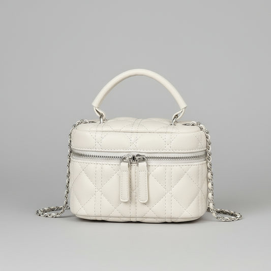 White quilted handbag with a chain detail on a wooden surface