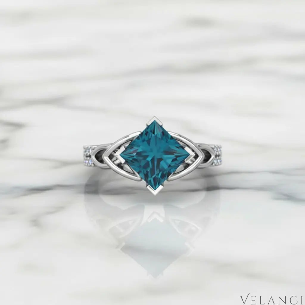 Silver ring with a large blue gemstone on a white background