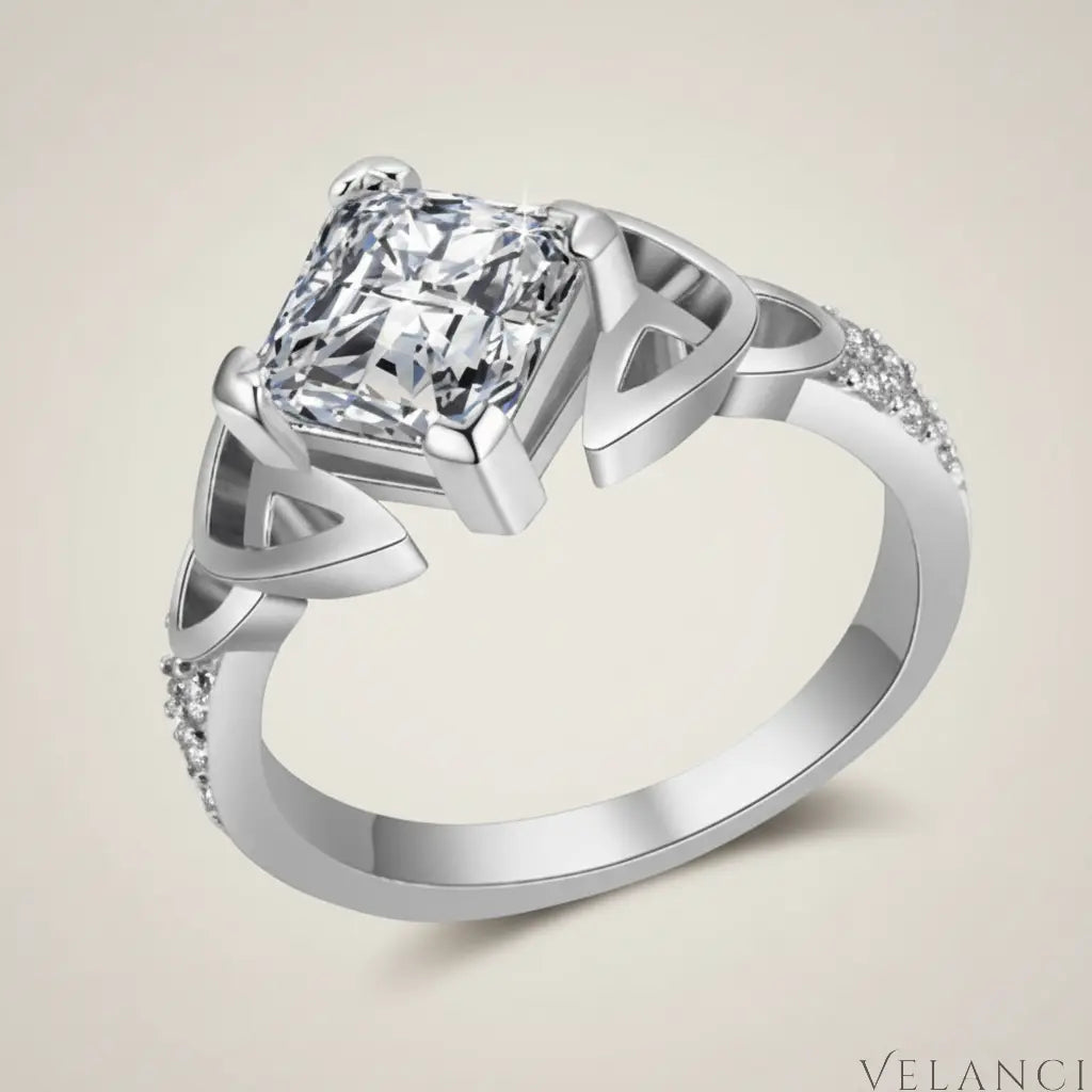 Silver ring with a large diamond and smaller diamonds on the band against a white background