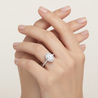 Hand wearing a diamond ring on a light background