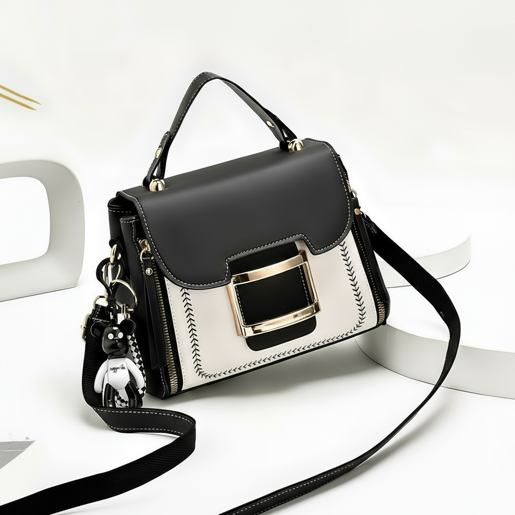 Black and white handbag with gold accents on a white background