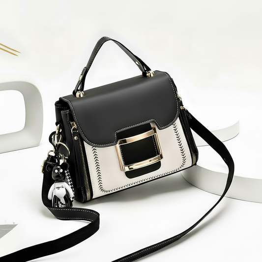 Black and white handbag with gold accents on a white background