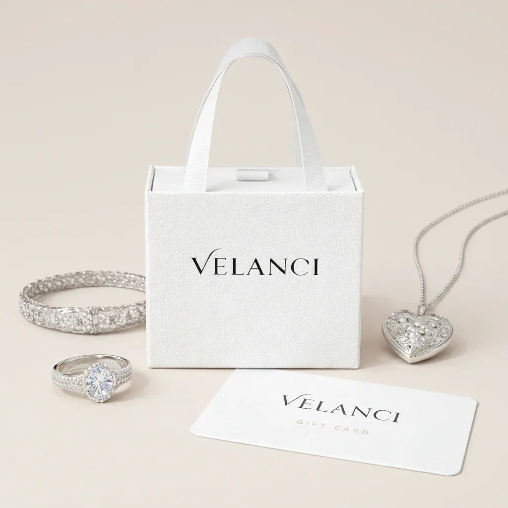 Silver jewelry set including a necklace, ring, and bracelet with a Velanci branded box on a white background.