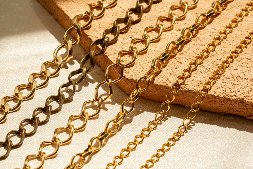 Gold chains on a textured beige surface